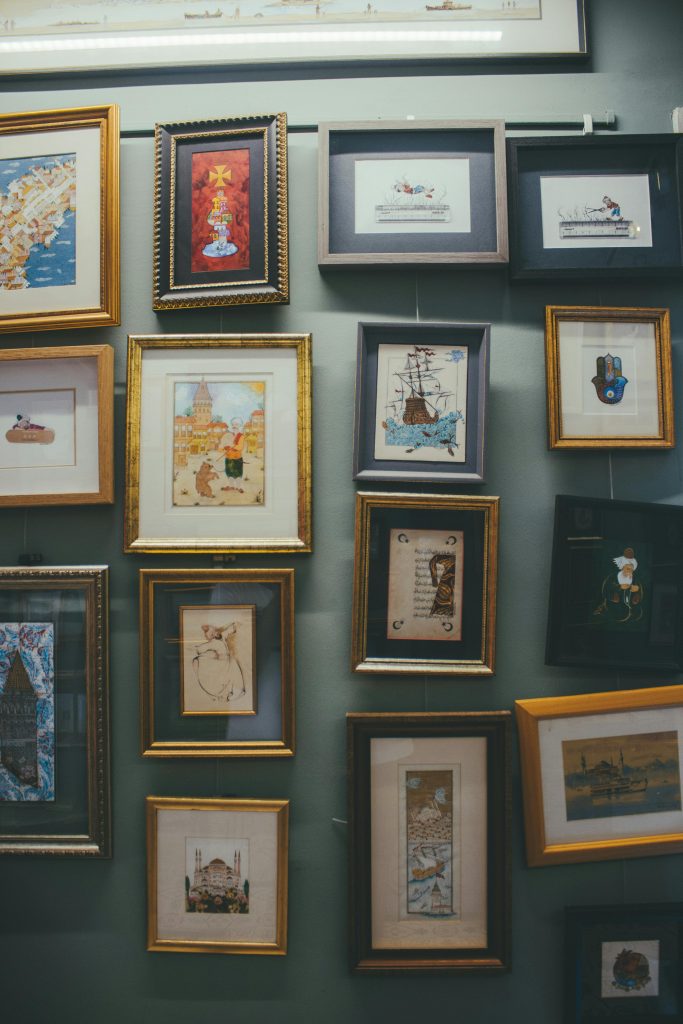 Collection of framed art and illustrations displayed on a gallery wall.